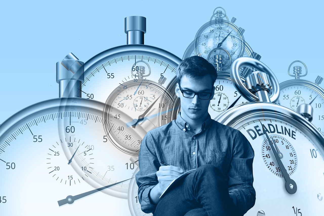 man taking notes in front of enlarged stop watches